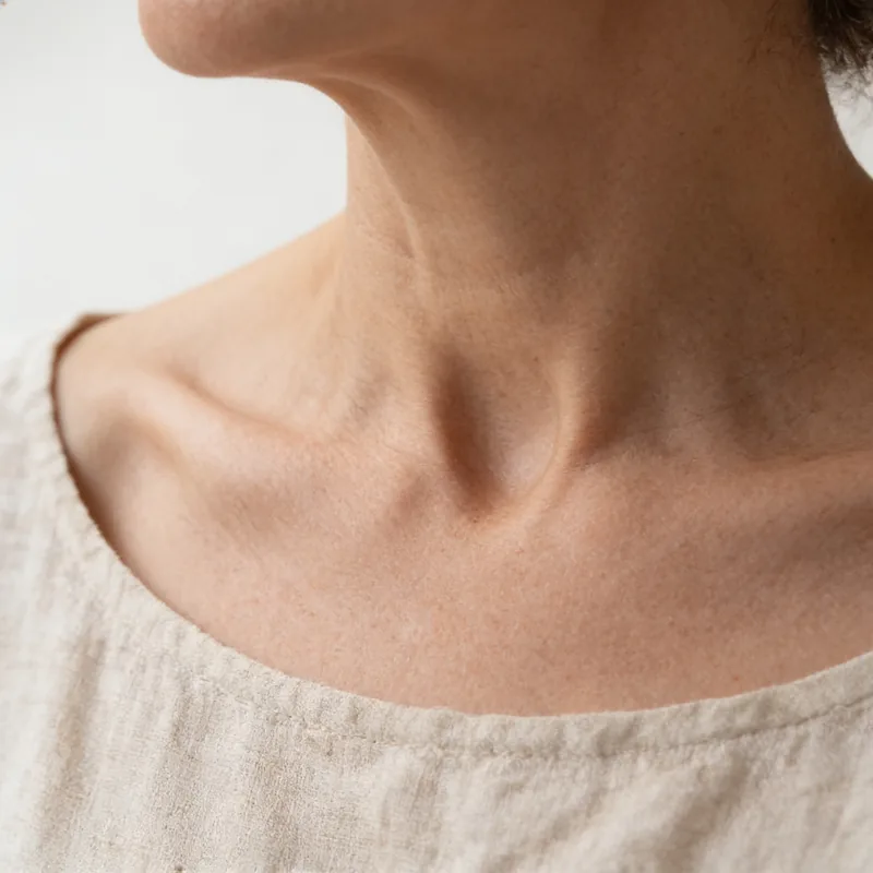 Collarbone and the base of the neck above a linen neckline.
