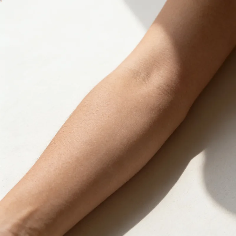 Inner forearm skin on unbleached linen showing natural tone variation.